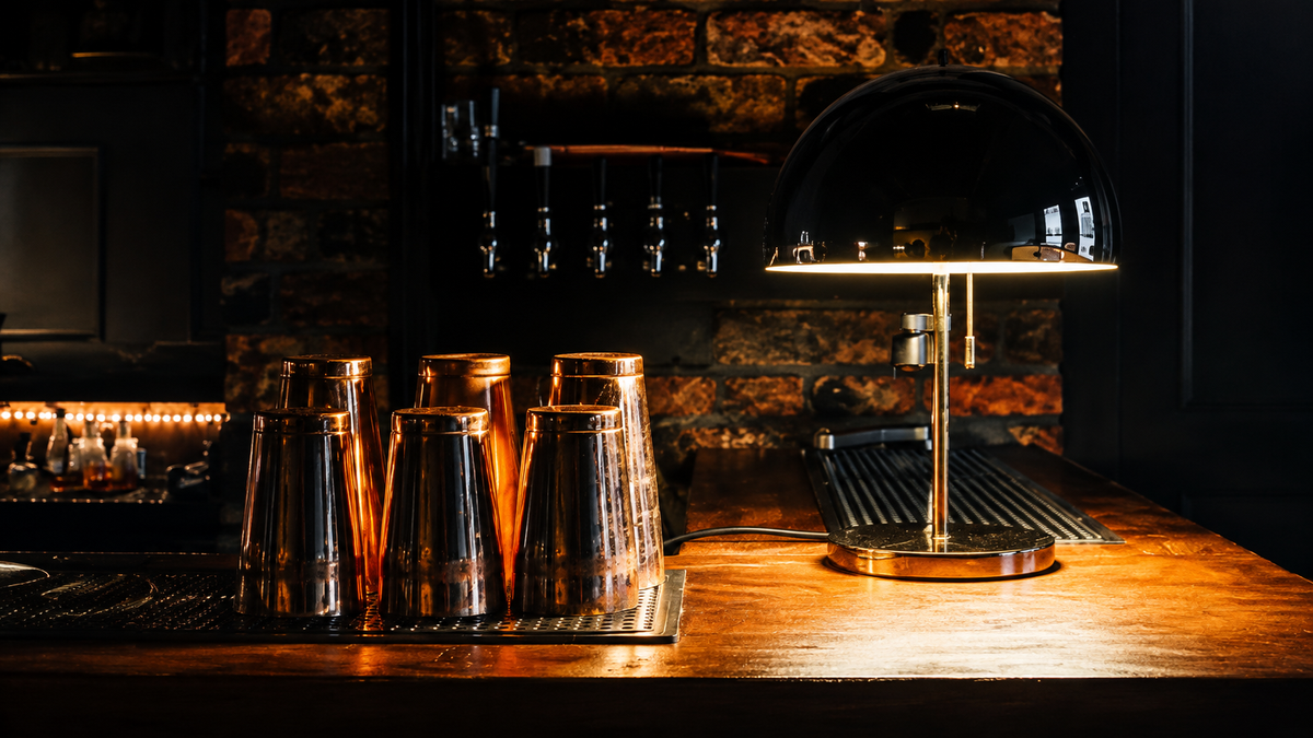 Stainless steel Boston shaker tins arranged on a professional bar counter ready for cocktail service